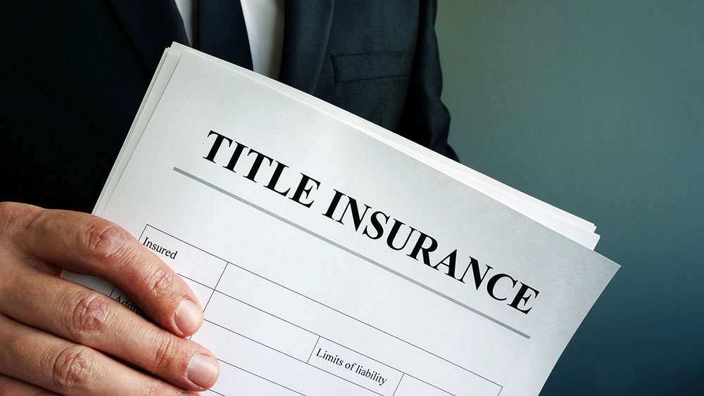 Title Insurance paperwork in the hands of a real estate agent