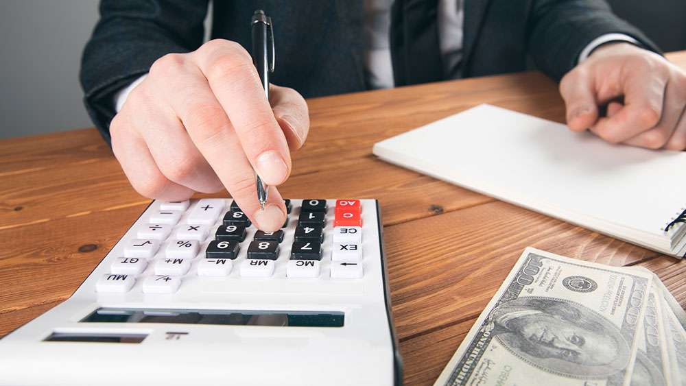 Hand on calculator at closing on a home