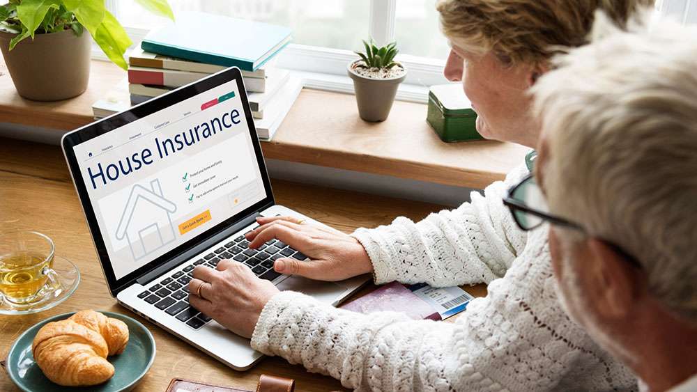 Couple using a computer to consider home insurance